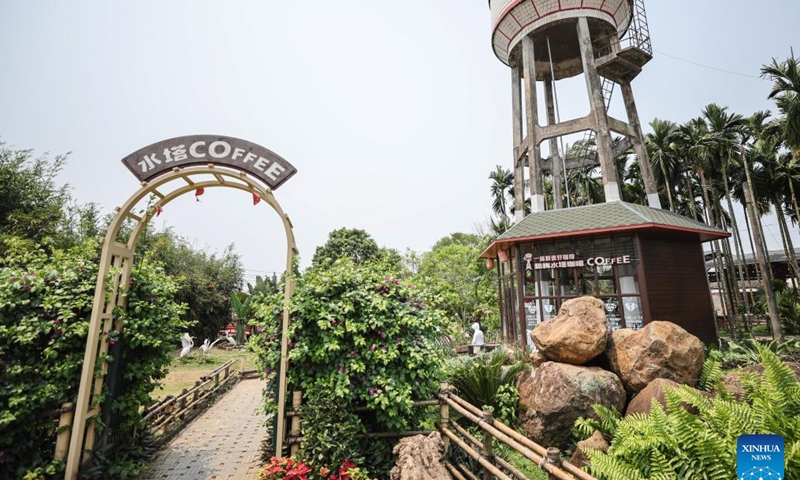 A tourist visits a water tower coffee house in Hemei Village of Longmen Township, Ding'an County, south China's Hainan Province, April 3, 2024. In recent years, Longmen Township in Ding'an County of Hainan has been developing its coffee tourism industry to attract tourists and promote its development. (Xinhua/Zhang Liyun)