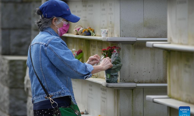A woman offers floral tributes to the deceased on Qingming Festival, or Tomb-Sweeping Day, at the Mountain View Cemetery in Vancouver, British Columbia, Canada, April 4, 2024. (Photo by Liang Sen/Xinhua)