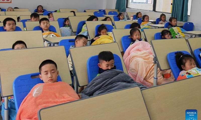 This photo taken with a mobile phone shows students taking noon naps at a classroom of a primary school in Fengyi sub-district of Zheng'an County in Zunyi City, southwest China's Guizhou Province, March 22, 2024. (Photo by Yu Yong/Xinhua)