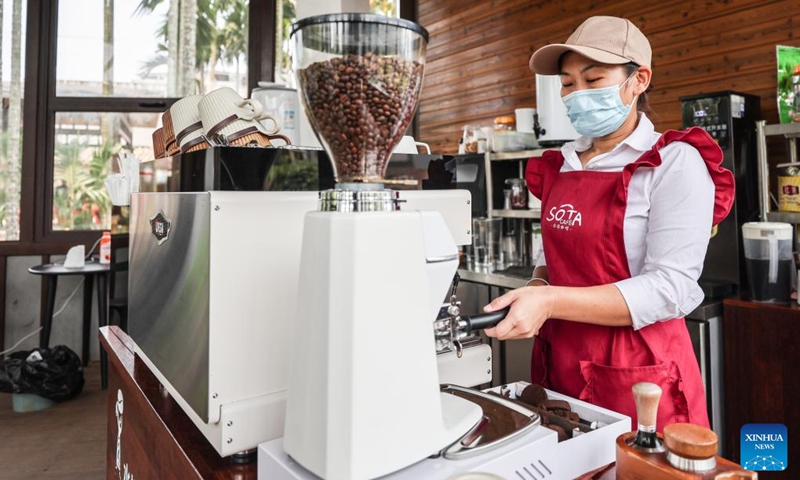 A staff member makes coffee at a water tower coffee house in Hemei Village of Longmen Township, Ding'an County, south China's Hainan Province, April 3, 2024. In recent years, Longmen Township in Ding'an County of Hainan has been developing its coffee tourism industry to attract tourists and promote its development. (Xinhua/Zhang Liyun)