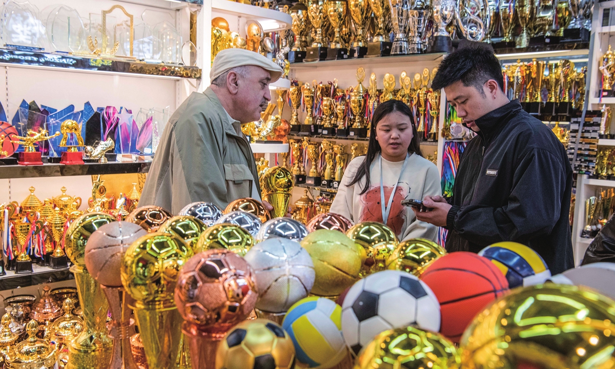 A businessman (left) from Georgia looks at trophies in Yiwu, East China’s Zhejiang Province on April 8, 2024. With the Paris Olympic Games approaching, Yiwu has ushered in a peak season for the sale of sporting goods, with people from all over the world shopping for balls, flags and trophies in a wide range of stores. Photo: VCG