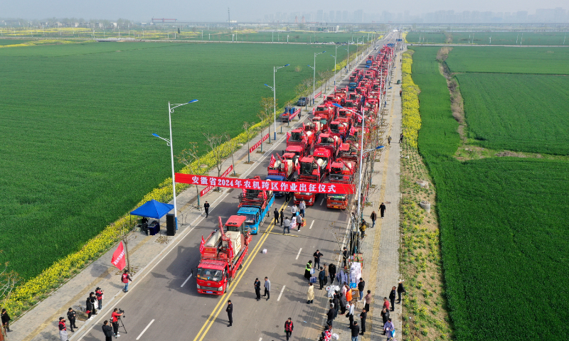 More than 60 agricultural machines loaded on trucks will support the grain harvest in more than 10 Chinese provinces, and they're seen  heading off from Mengcheng county, East China's Anhui Province, on April 8, 2024. In 2024, Mengcheng county will send more than 1,500 harvesters to participate in cross-regional grain harvesting operations, which is expected to generate income of nearly 300 million yuan ($41.5 million). Photo: VCG
