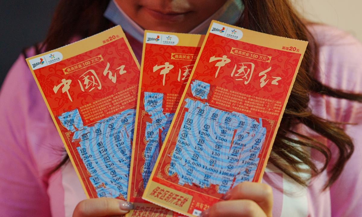 A customer shows off three used scratch tickets.  Photo: VCG