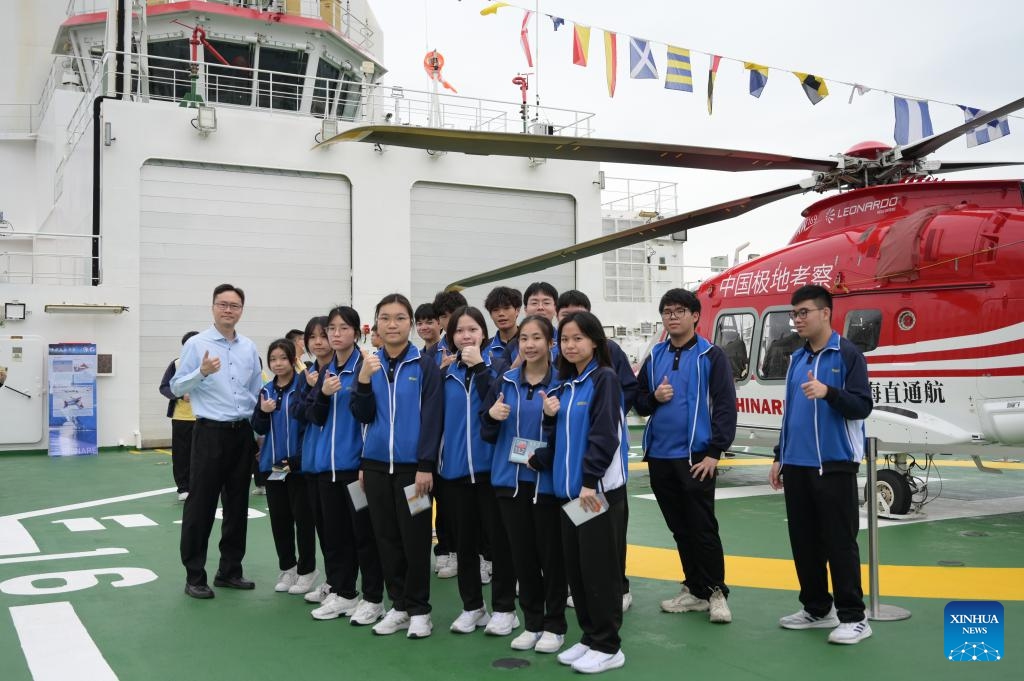 A teacher and students pose on the deck of the polar icebreaker Xuelong 2 in Hong Kong, south China, April 9, 2024. China's first domestically made icebreaker Xuelong 2 on Monday arrived in the country's Hong Kong Special Administrative Region (HKSAR) for a five-day visit. Xuelong 2, which came to Hong Kong for the very first time, entered the Ocean Terminal in Tsim Sha Tsui on Monday morning after completing their latest Antarctic expedition.(Photo: Xinhua)