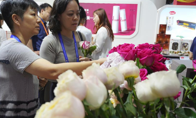 Visitors select roses at the Yunnan booth of the fourth China International Consumer Products Expo (CICPE) in Haikou, capital city of south China's Hainan Province, April 14, 2024. A batch of domestic brands have attracted a lot of visitors at the expo. (Xinhua/Li Mengjiao)