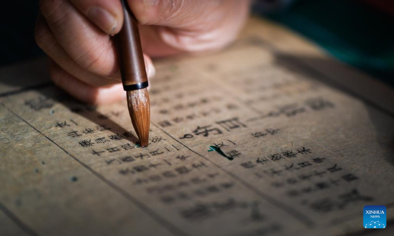 Zhang Qi, a restorer of ancient books in the library of Jilin University, mends the pages of an ancient book at the library of Jilin University in Changchun, northeast China's Jilin Province, April 19, 2024. (Xinhua/Xu Chang)