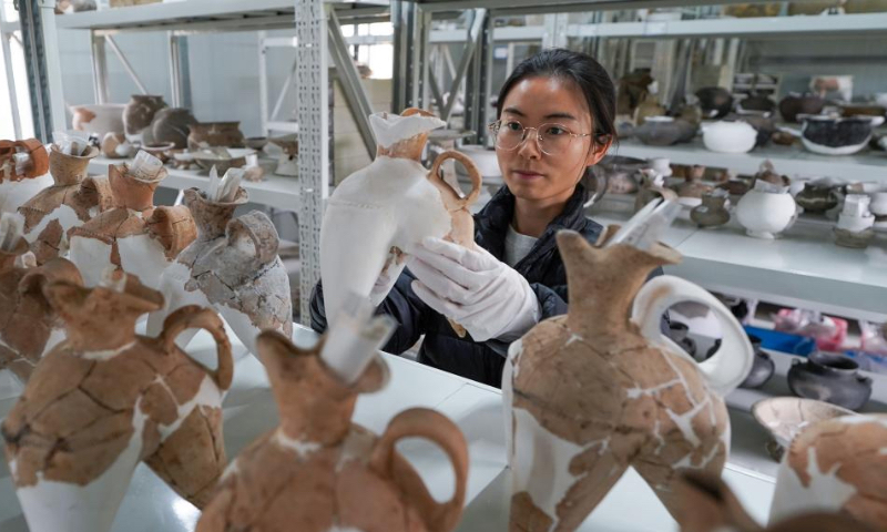 A staff member of Nanjing Museum arranges relics at a work station of Sidun Site in Changzhou, east China's Jiangsu Province, April 8, 2024. (Xinhua/Li Bo)