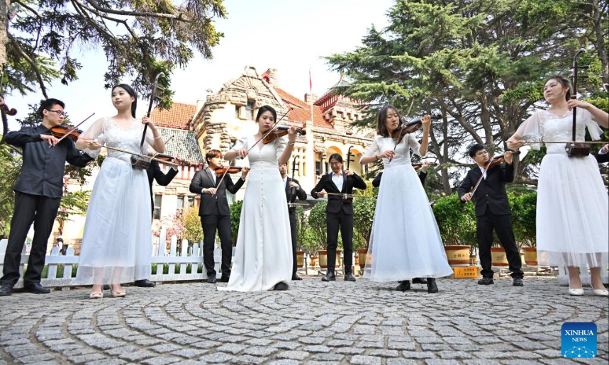 Students from the Ocean University of China perform outside the Museum of Former German Governor's House in Qingdao, east China's Shandong Province, April 18, 2024. This year, students from the Ocean University of China have staged several performances for public welfare in the city of Qingdao, as part of the aesthetic education. (Xinhua/Li Ziheng)