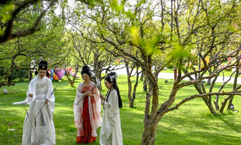 Tourists donning traditional Hanfu attire have fun at the Tang Paradise, a complex based on the site of the original relic of an imperial garden dating back to the Tang Dynasty (618-907), in Xi'an, northwest China's Shaanxi Province, April 11, 2024. Xi'an, one of the ancient capitals in Chinese history, is a popular tourist destination specially in this spring. It indulges visitors with the beauty of blossom flowers and immersive cultural experiences at the landmark cultural sites such as ancient city walls, Giant Wild Goose Pagoda, Qinglong Temple, Daming Palace National Heritage Park, etc. (Xinhua/Zou Jingyi)