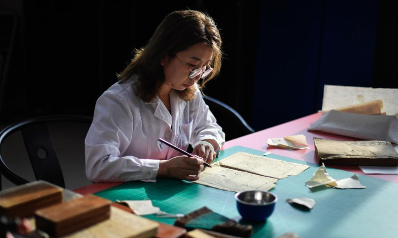 Zhang Hua, a restorer of ancient books in the library of Jilin University, works on the restoration of an ancient book at the library of Jilin University in Changchun, northeast China's Jilin Province, April 19, 2024.