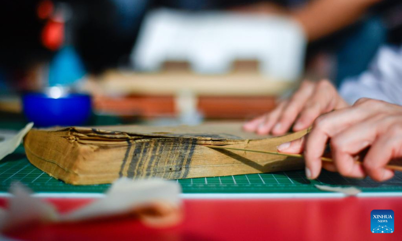 Zhang Hua, a restorer of ancient books in the library of Jilin University, prepares for the restoration of an ancient book at the library of Jilin University in Changchun, northeast China's Jilin Province, April 19, 2024. (Xinhua/Xu Chang)
