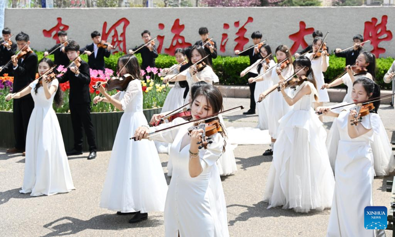 Students perform at the gate of Ocean University of China in Qingdao, east China's Shandong Province, April 18, 2024. This year, students from the Ocean University of China have staged several performances for public welfare in the city of Qingdao, as part of the aesthetic education. (Xinhua/Li Ziheng)