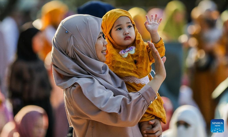 A mother and her child wave as they attend a prayer in celebration of the Eid al-Fitr in Quezon City, the Philippines, on April 10, 2024.(Photo: Xinhua)