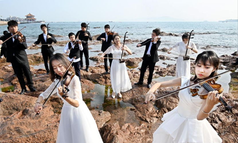 Students from the Ocean University of China perform at the Zhanqiao Bridge scenic spot in Qingdao, east China's Shandong Province, April 18, 2024.