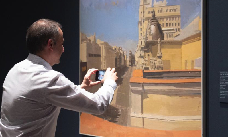 A visitor takes photos at an exhibition featuring contemporary oil paintings from China and Spain at Palacio Real, in Madrid, Spain, on April 12, 2024. (Photo by Gustavo Valiente/Xinhua)