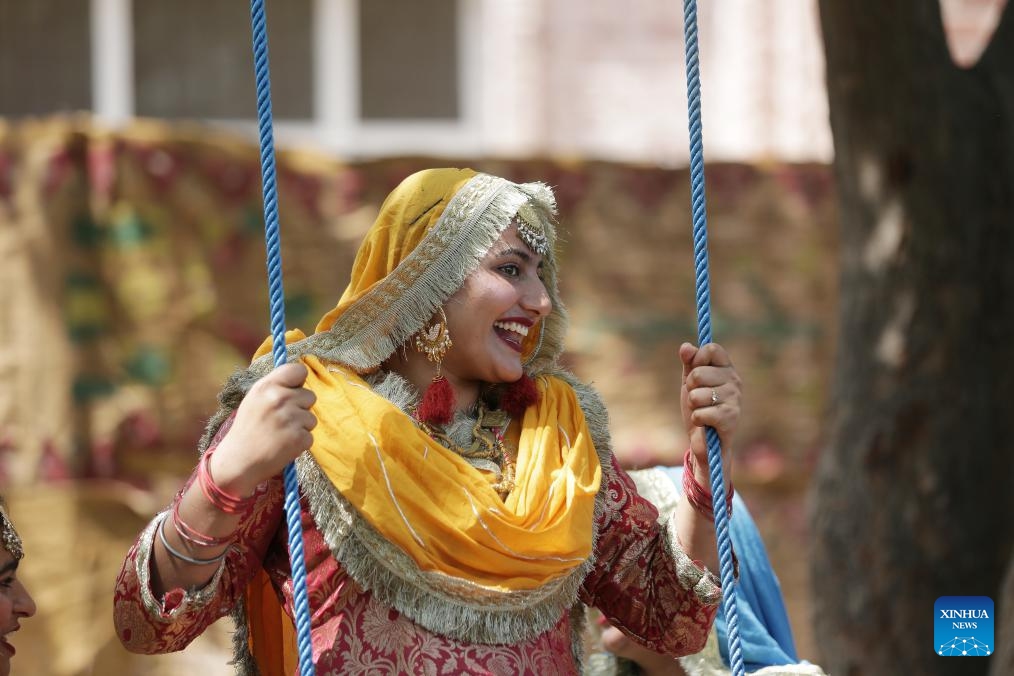 A woman wearing traditional Punjabi attire is pictured on a swing during a fair celebrating the Baisakhi festival at a college in Amritsar district of India's northern Punjab state, April 9, 2024. Baisakhi is one of the most popular festivals celebrated in the Indian state of Punjab to mark the harvest.(Photo: Xinhua)