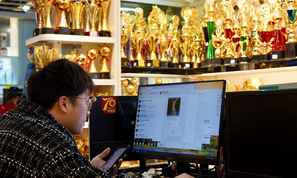 A merchant selling trophies checks online orders on April 10, 2024, in Yiwu, East China's Zhejiang Province. As the Paris 2024 Olympic Games draws near, some merchants selling sports-related products have seen a spike in export orders. Photo: cnsphoto