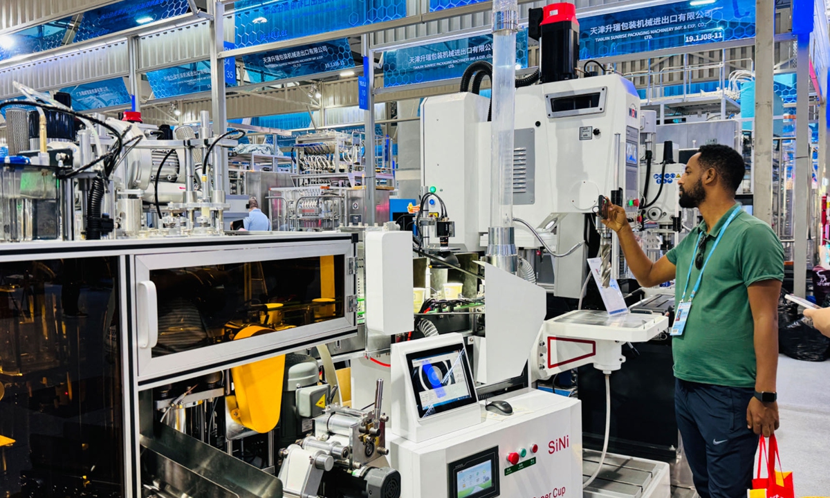 A visitor takes photos of an automated production line on display at the 135th session of the Canton Fair in Guangzhou, South China's Guangdong Province, on April 16, 2024. Photo: Chi Jingyi/GT