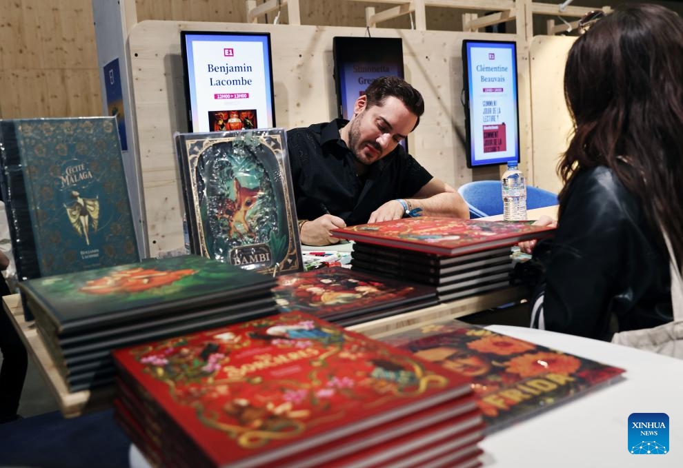 French artist, author and illustrator Benjamin Lacombe signs for readers during the Paris Book Festival 2024 in Paris, France, April 14, 2024. The three-day event concluded here on Sunday.(Photo: Xinhua)