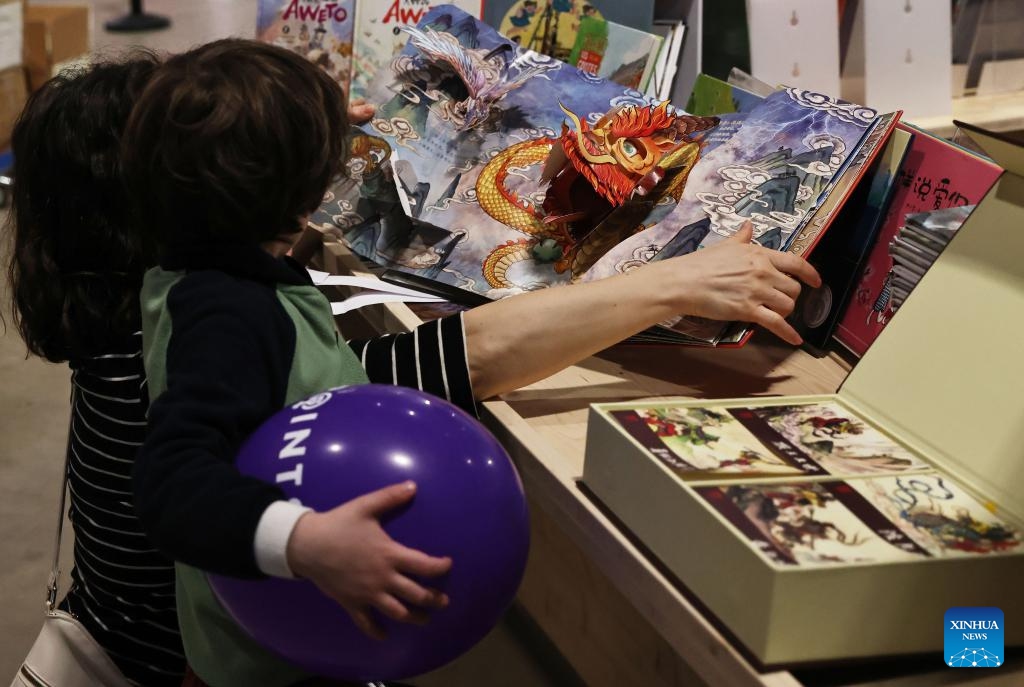 People read Chinese children's books during the Paris Book Festival 2024 in Paris, France, April 14, 2024. The three-day event concluded here on Sunday.(Photo: Xinhua)