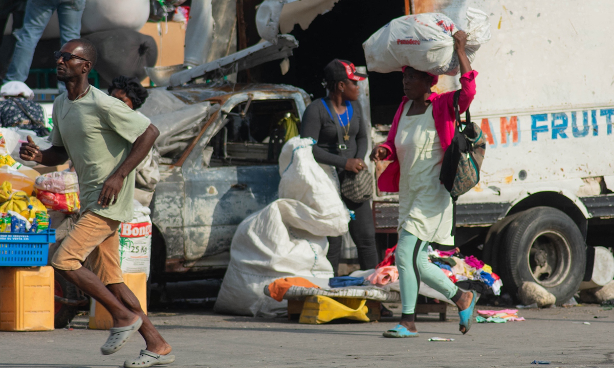 People run after reportedly hearing gunshots in Port-au-Price, Haiti, on April 13, 2024. Photo: AFP