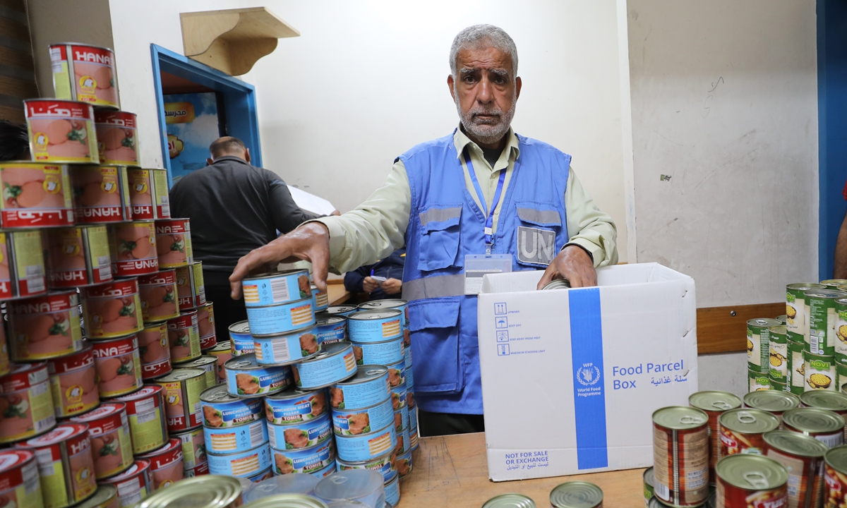 World Food Programme (WFP) officials provide food aid to Palestinians staying in a shelter in Gaza, on April 17, 2024. According to the WFP, in March, it delivered around 900 million tons of food via six convoys into northern Gaza, utilizing a new route that has increased the frequency of deliveries. Photo: VCG