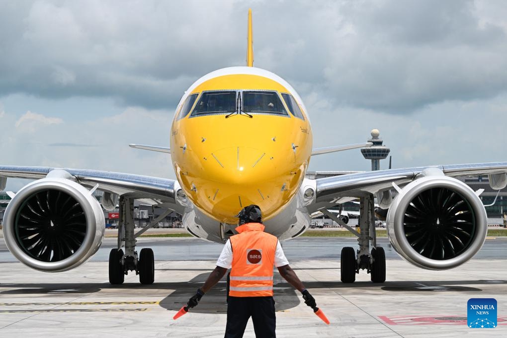 An Embraer E190-E2 passenger aircraft of Singaproe's budget airline Scoot is pictured at Singapore's Changi Airport in Singapore on April 15, 2024. Singapore's low-cost airline Scoot held a ceremony at the Changi Airport to receive its first Embraer E 190-E2 jetliner Monday, according to the airline. Named Explorer 3.0, the aircraft departed from Brazil on April 12 and made several fuel stops before receiving water cannon greetings in Singapore.(Photo: Xinhua)