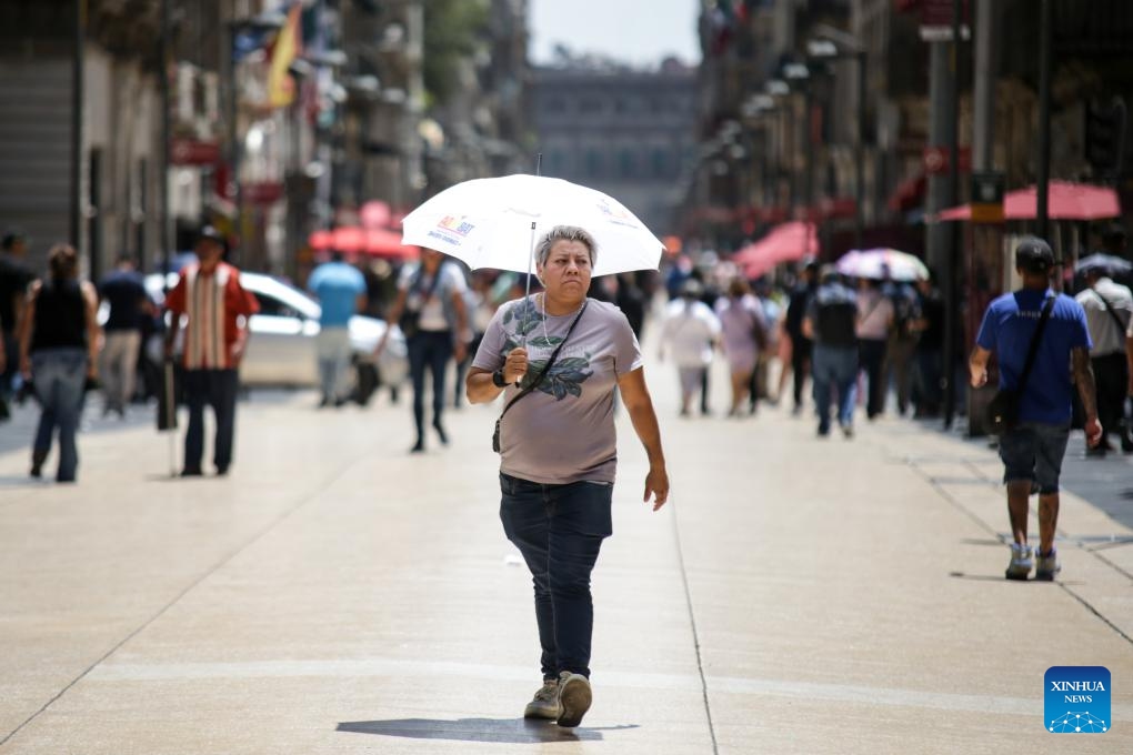 A woman shields herself from the sun with an umbrella in Mexico City, Mexico, on April 16, 2024.(Photo: Xinhua)