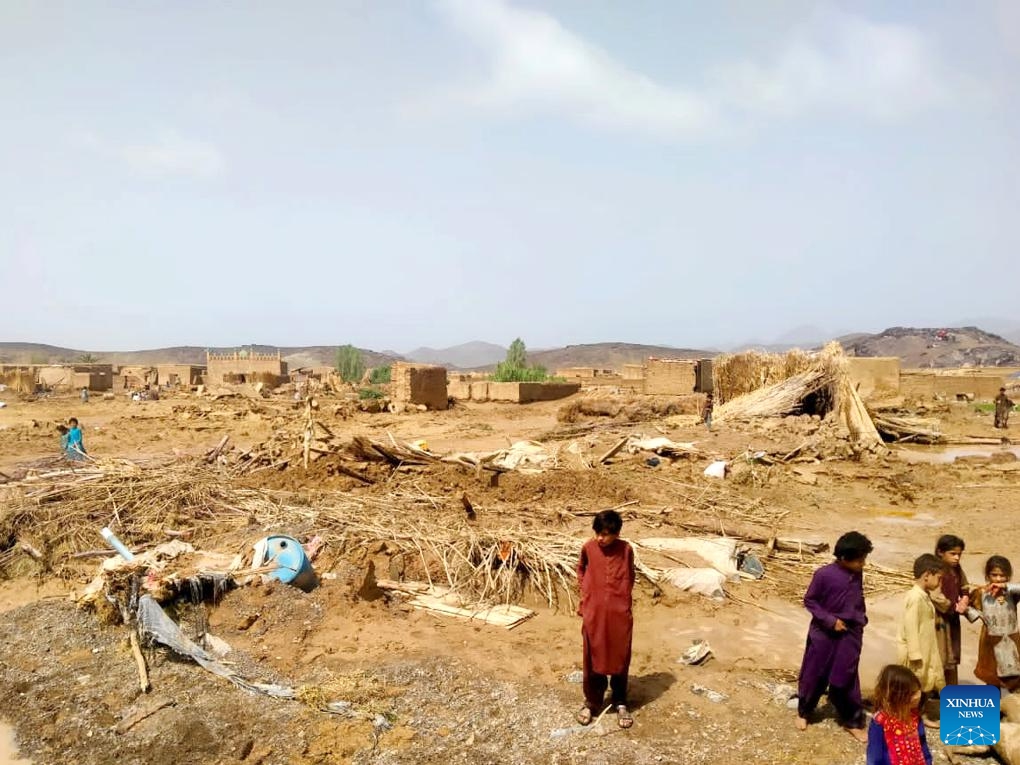 Photo taken with a mobile phone on April 16, 2024 shows children standing near houses damaged in a heavy rain in Balochistan province, Pakistan. Heavy rains and lightning caused havoc in different areas of Pakistan causing 71 deaths and injuries to 67 others since Saturday, an official told Xinhua Wednesday.(Photo: Xinhua)