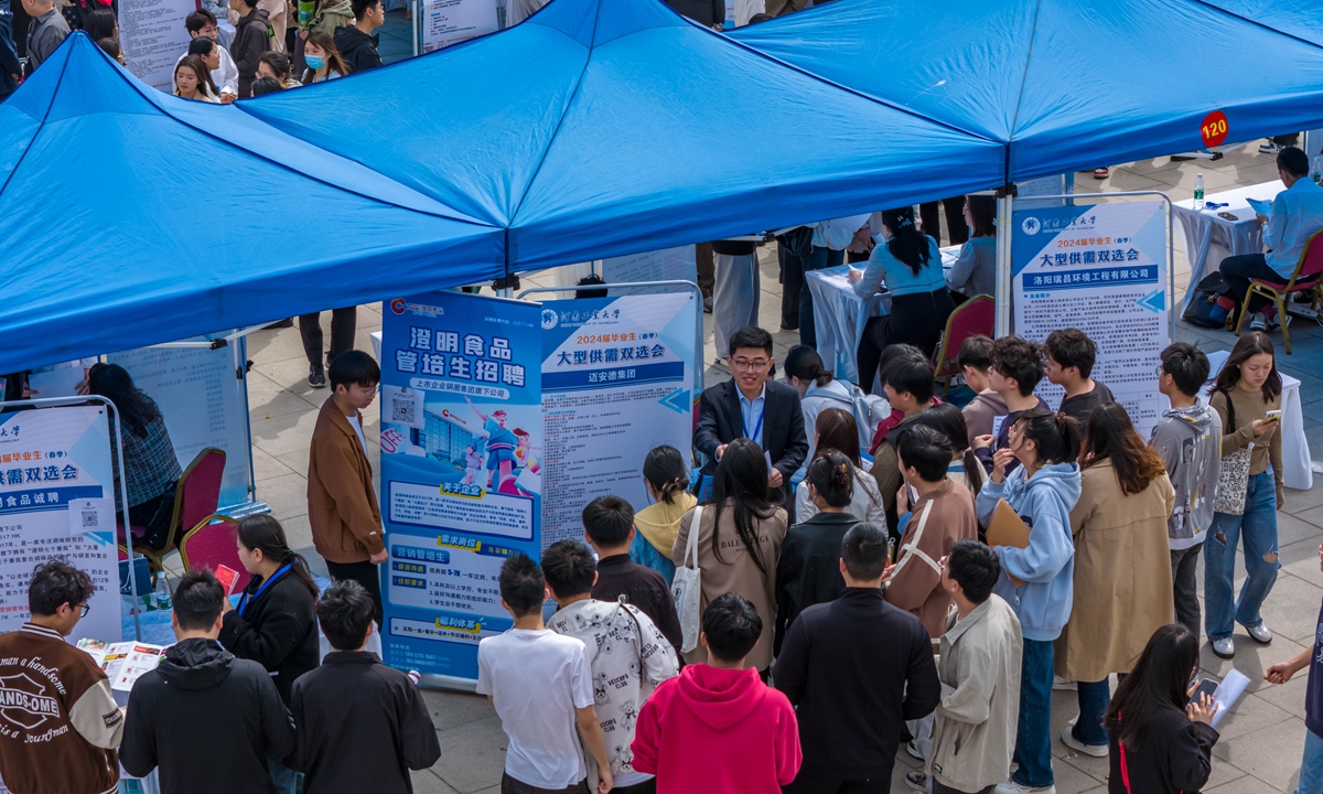 Students actively talk with company representatives during the job fair at the Henan University of Technology in Zhengzhou, Central China's Henan Province, on March 30, 2024. Photo: VCG