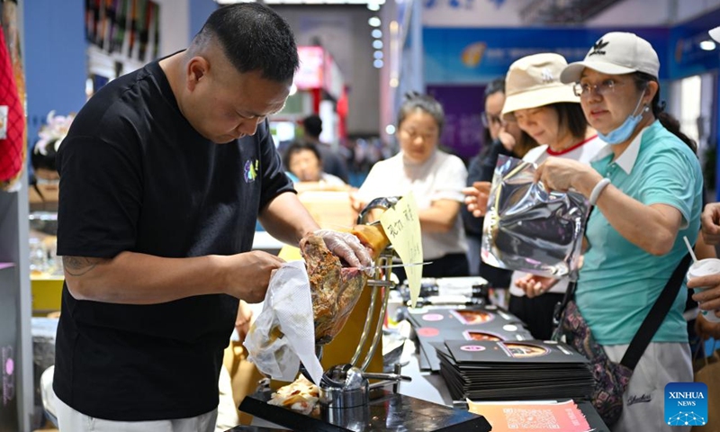 Visitors select the Spanish ham at the fourth China International Consumer Products Expo in Haikou, capital city of south China's Hainan Province, April 17, 2024. The expo opened to the public on Wednesday.(Photo: Xinhua)