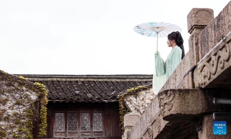 A tourist donning traditional Hanfu attire visits the water town Wuzhen in Jiaxing City, east China's Zhejiang Province, April 11, 2024. Located in east China's Zhejiang Province, the waterside city Jiaxing is renowned for tourist destinations Nanhu Lake and Wuzhen. In the breezy month of April, the two tourist hotspots come alive with the gentle touch of spring. Nanhu Lake, with its shimmering waters and willow trees swaying along the lakeside, is a sight to behold.(Photo: Xinhua)
