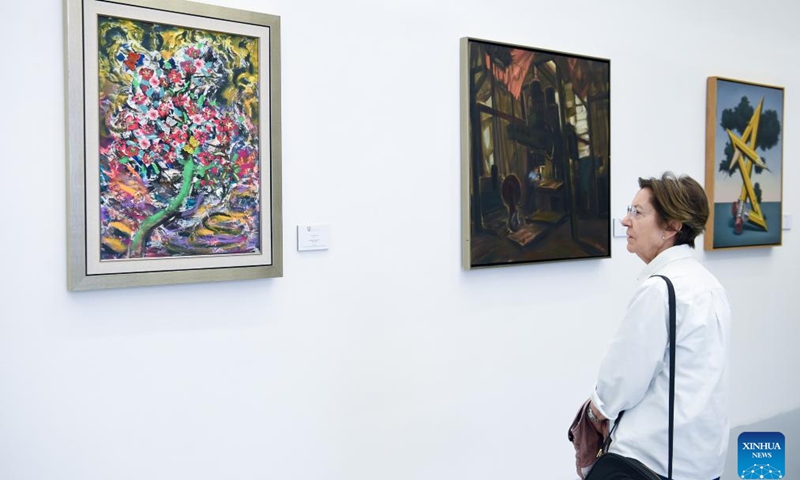 A woman views art works during the Chinese contemporary art exhibition Fluyendo naturalmente at China Cultural Center in Madrid, Spain, April 16, 2024.(Photo: Xinhua)