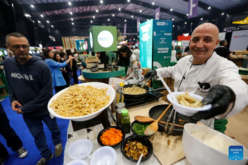 An exhibitor passes food to visitors at the 28th edition of HORECA Lebanon, an annual trade fair for the hospitality industry, in Beirut, Lebanon, on April 17, 2024. The event, held under the theme of embrace the future, kicked off here on April 16 and will last until April 19.(Photo: Xinhua)