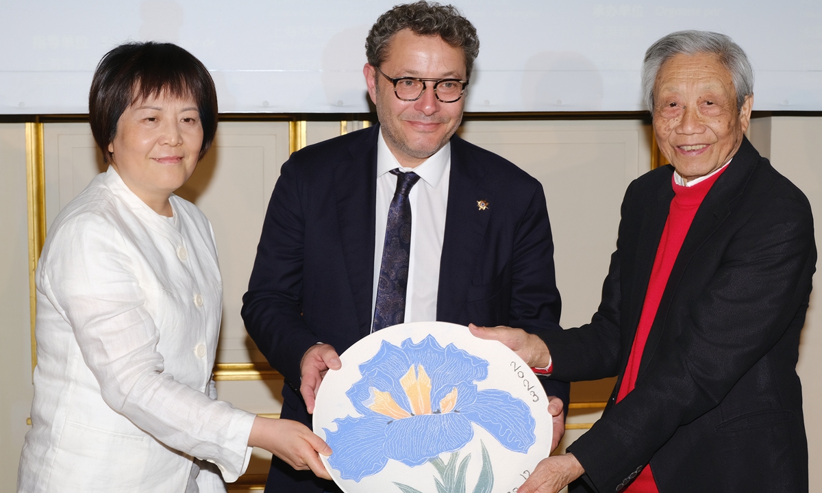Li Yun (left), president of Shanghai United Media Group, and Chen Jialing (right), a renowned ink painting artist, present Vincent Louault, a vice-president of the French Senate's France-China Friendship Group, with a porcelain plate designed by Chen. (Photo: Courtesy of event organizer)