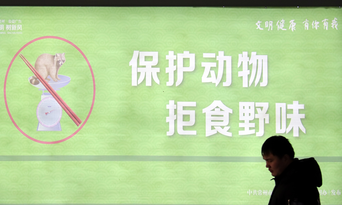 A man passes by a public service wall promoting the protection of wildlife and rejecting the consumption of wild animals in Changzhou, East China's Jiangsu Province, on January 12, 2024. Photo: VCG