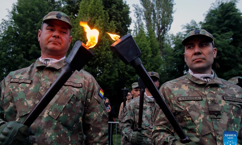 Soldiers light torches before a march to celebrate the upcoming Romanian Land Forces Day, in Bucharest, Romania, April 21, 2024. (Photo by Cristian Cristel/Xinhua)