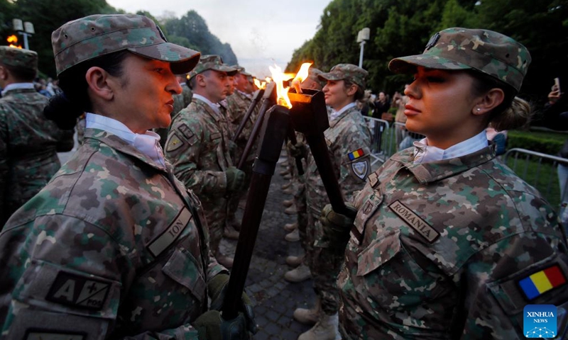 Soldiers light torches before a march to celebrate the upcoming Romanian Land Forces Day, in Bucharest, Romania, April 21, 2024. (Photo by Cristian Cristel/Xinhua)