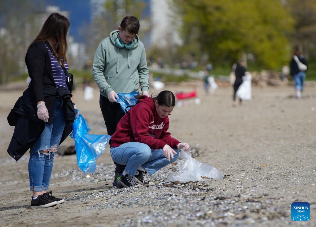 Volunteers clean up the beach to mark the upcoming Earth Day in Vancouver, British Columbia, April 21, 2024. (Photo by Liang Sen/Xinhua)