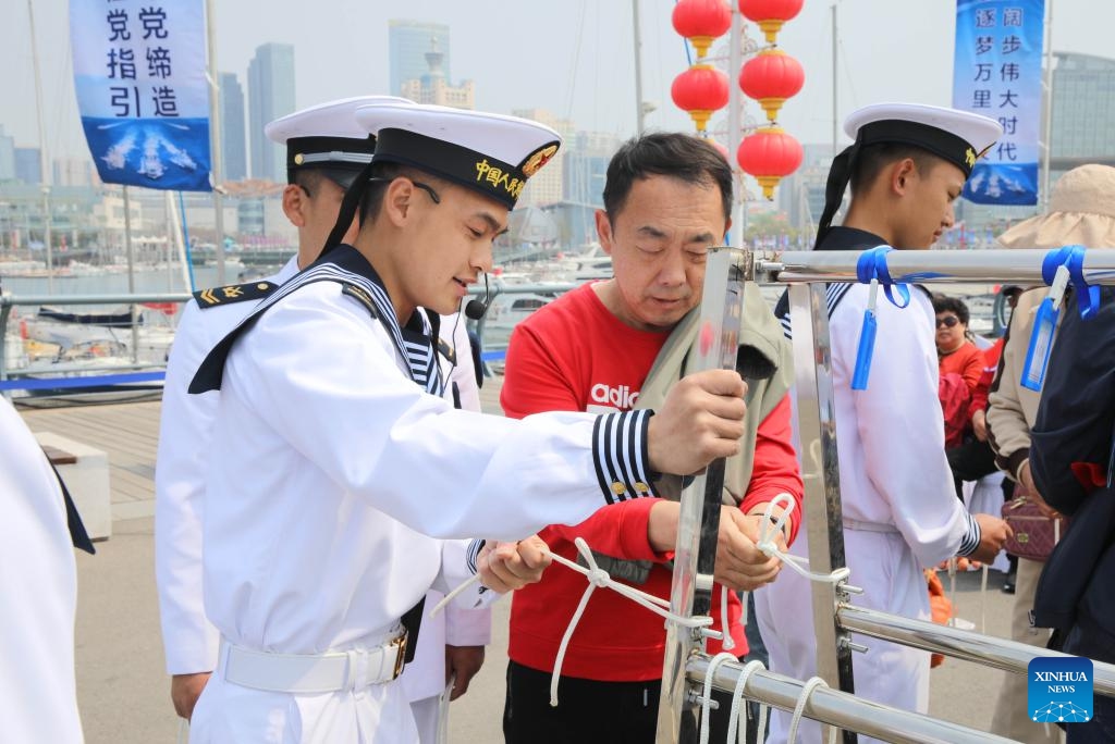 A visitor learns to tie knot at the Qingdao International Sailing Center pier in Qingdao, east China's Shandong Province, April 22, 2024. The Chinese People's Liberation Army Navy holds open day events in multiple coastal cities including Qingdao around April 23 to mark the 75th anniversary of its founding.(Photo: Xinhua)