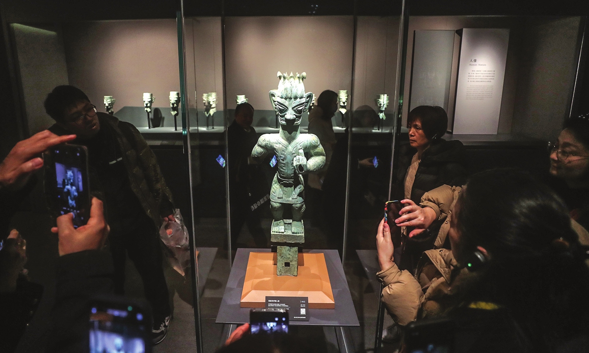 Visitor take pictures of a bronze figure statue from Sanxingdui Ruins at an exhibition in the Shanghai Museum on Febriuary 2, 2024. Photo: VCG
