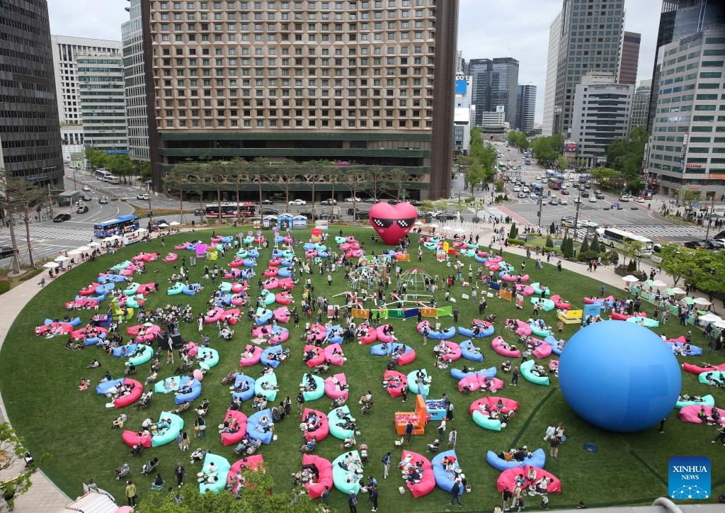 People read at Seoul Plaza in Seoul, South Korea, April 21, 2024. Seoul Outdoor Library opens to the public on April 18. The Seoul city government has set up lending services counters, beanbags, leisure chairs and other facilities in Seoul Plaza, Gwanghwamun Plaza and Cheonggyecheon Stream to encourage citizens and tourists to enjoy reading outdoors. 2024 Seoul Outdoor Library will remain open until November 10.(Photo: Xinhua)