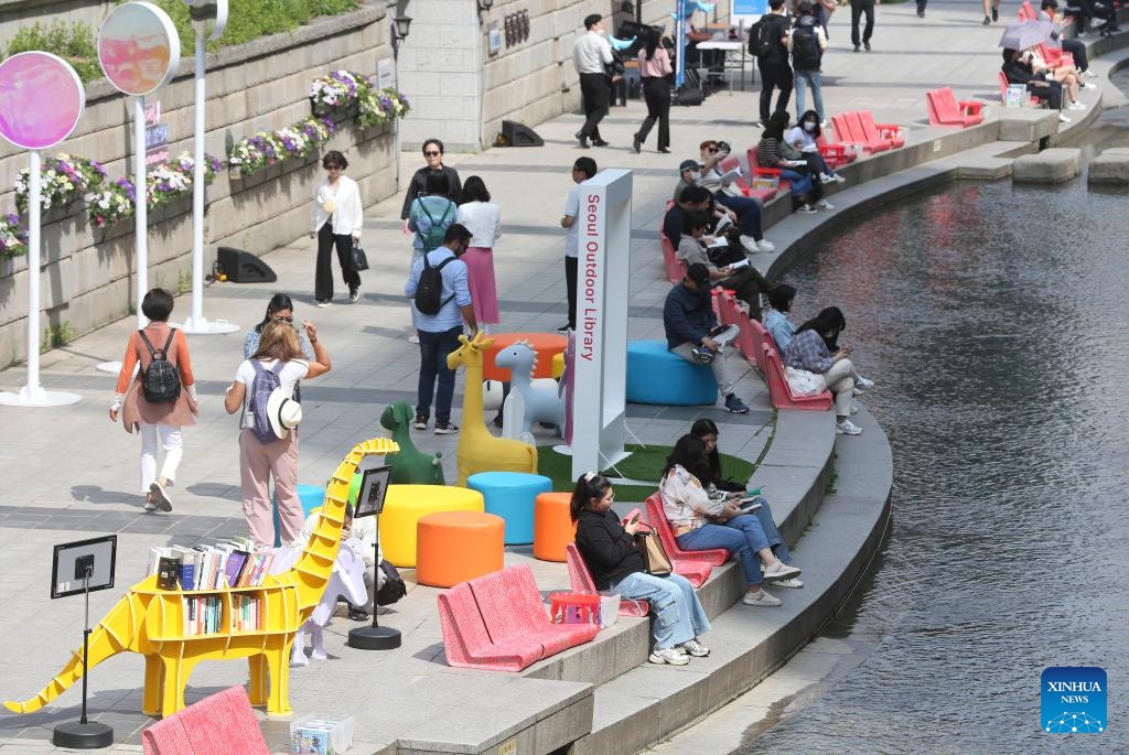 People read at Seoul Plaza in Seoul, South Korea, April 21, 2024. Seoul Outdoor Library opens to the public on April 18. The Seoul city government has set up lending services counters, beanbags, leisure chairs and other facilities in Seoul Plaza, Gwanghwamun Plaza and Cheonggyecheon Stream to encourage citizens and tourists to enjoy reading outdoors. 2024 Seoul Outdoor Library will remain open until November 10.(Photo: Xinhua)
