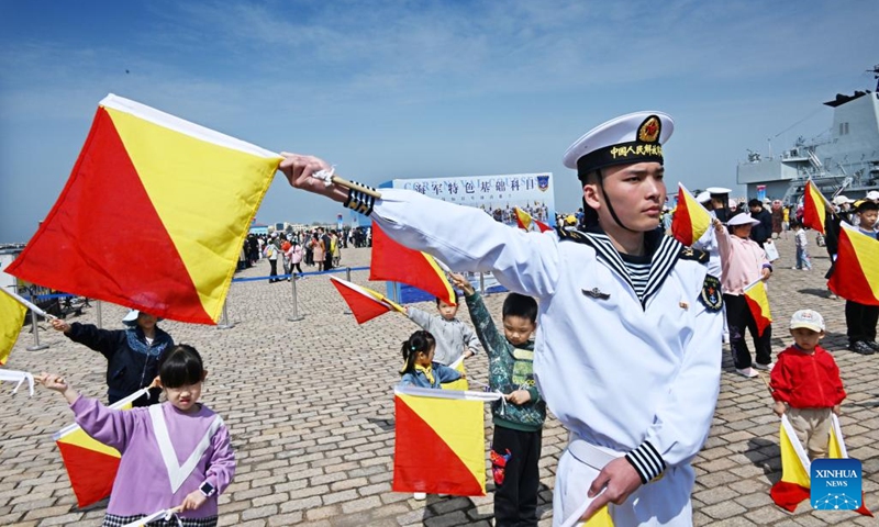 Children learn flag language at the pier 3 in Qingdao Port of Qingdao, east China's Shandong Province, April 21, 2024. The Chinese People's Liberation Army Navy holds open day events in multiple coastal cities including Qingdao around April 23 to mark the 75th anniversary of its founding.(Photo: Xinhua)