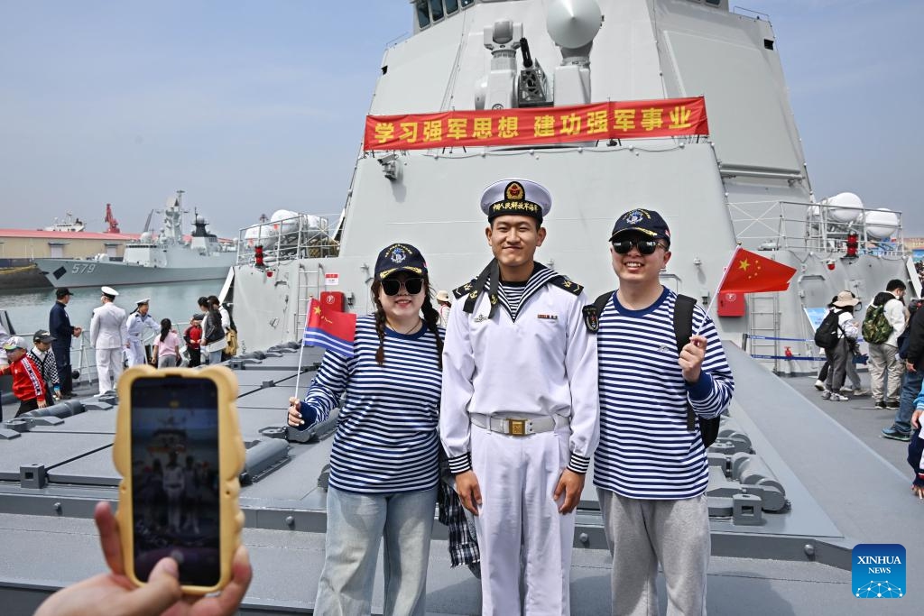 People pose for photos with a navel soldier on the missile destroyer Guiyang at the pier 3 in Qingdao Port of Qingdao, east China's Shandong Province, April 21, 2024. The Chinese People's Liberation Army Navy holds open day events in multiple coastal cities including Qingdao around April 23 to mark the 75th anniversary of its founding.(Photo: Xinhua)