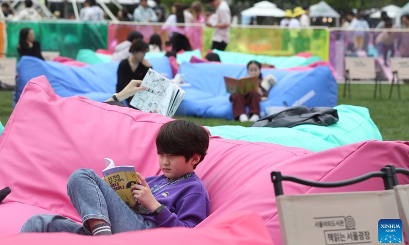 People read at Seoul Plaza in Seoul, South Korea, April 21, 2024. Seoul Outdoor Library opens to the public on April 18. The Seoul city government has set up lending services counters, beanbags, leisure chairs and other facilities in Seoul Plaza, Gwanghwamun Plaza and Cheonggyecheon Stream to encourage citizens and tourists to enjoy reading outdoors. 2024 Seoul Outdoor Library will remain open until November 10.(Photo: Xinhua)
