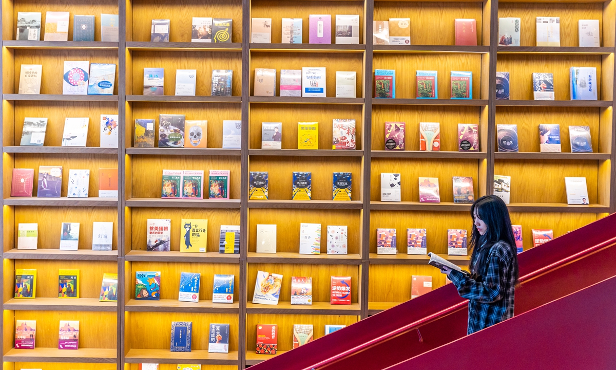 A woman reads a book at a bookstore in Nanjing, East China's Jiangsu Province, on April 23, 2024, World Book and Copyright Day. Each year, people all over the world mark this occasion to recognize the importance of books - a link between the past and the future, a bridge between generations and across cultures. Photo: VCG