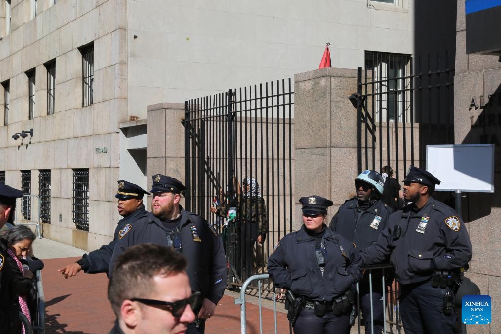 New York police officers stand guard at a gate of Columbia University's Morningside Heights campus in New York City, the United States, April 22, 2024. All classes at Columbia University went virtual starting on Monday as divisive demonstrations and debates around the Israel-Hamas conflict heated up on campus recently.(Photo: Xinhua)