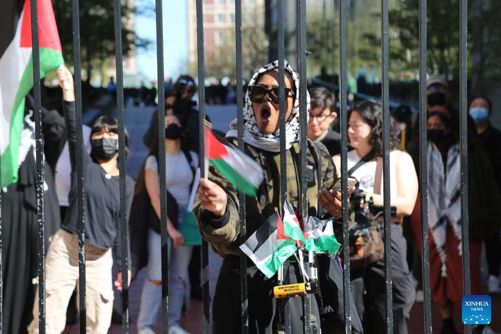 A student activist chants slogans inside a gate of Columbia University's Morningside Heights campus in New York City, the United States, April 22, 2024. All classes at Columbia University went virtual starting on Monday as divisive demonstrations and debates around the Israel-Hamas conflict heated up on campus recently.(Photo: Xinhua)