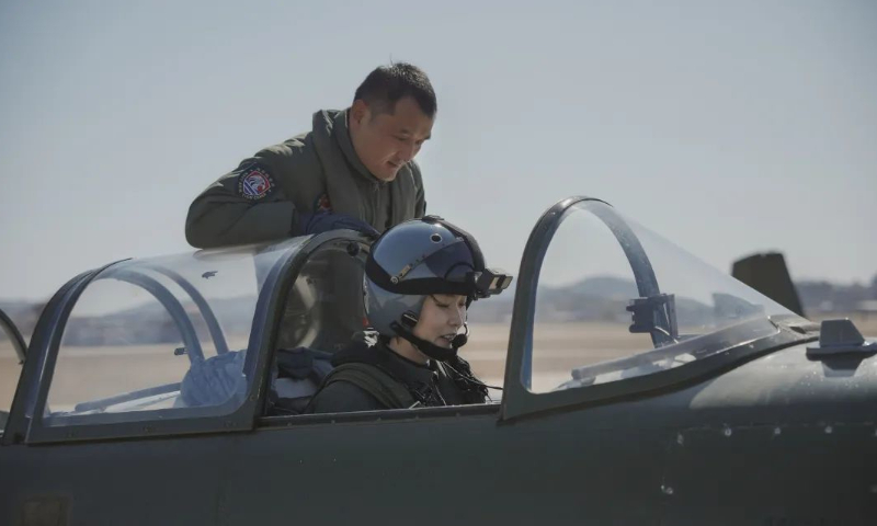 A member of the first group of female carrier-based aircraft pilots in China prepares for a maiden flight. A flight instructor guides the trainee pilot. Photo: Chen Chao